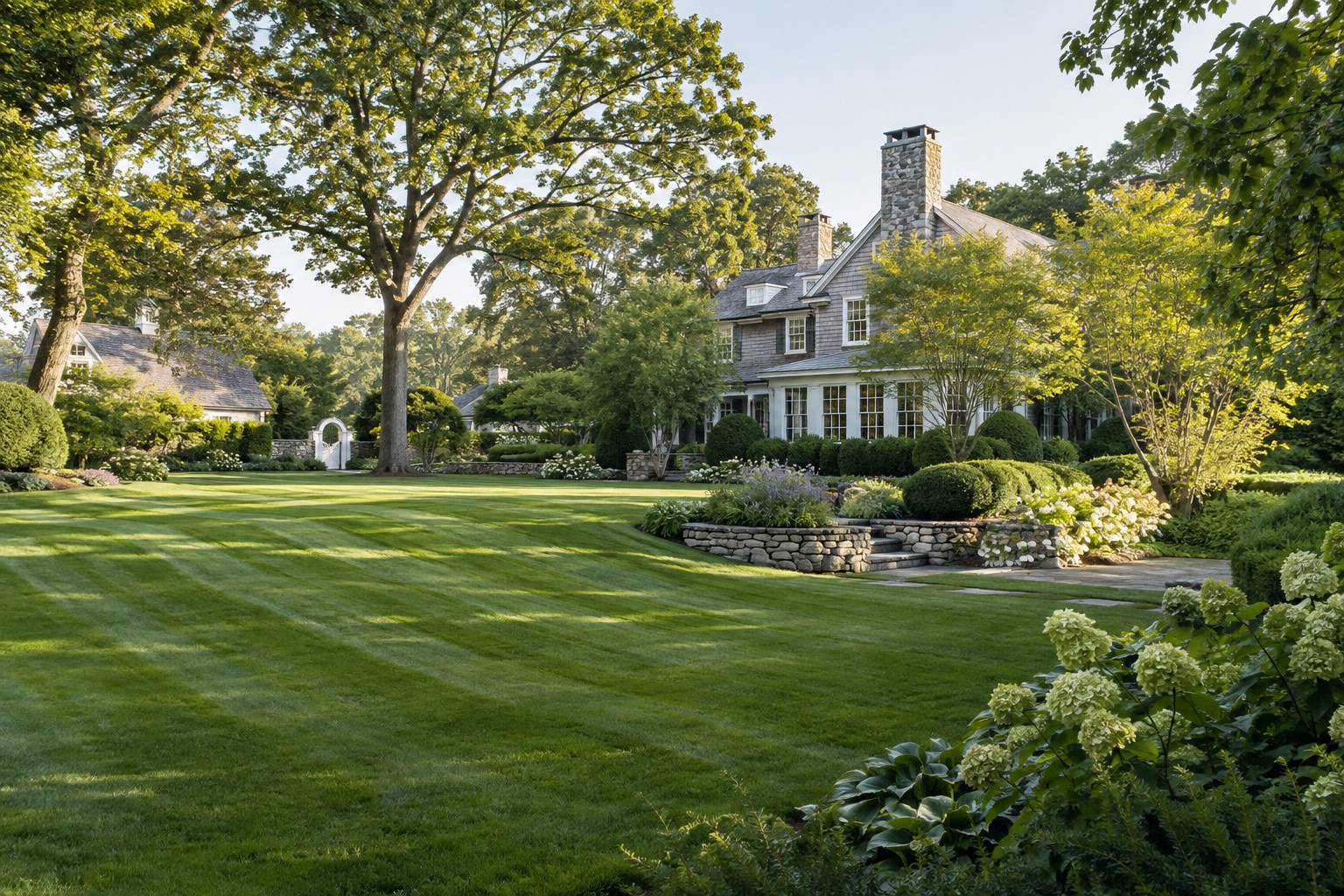 Managed Fairfield County estate with maintained lawn and layered landscaping